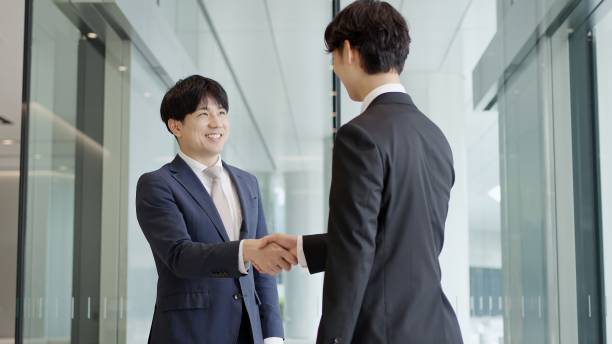 istock Asian businessmen shaking hands in a lobby 2193366334