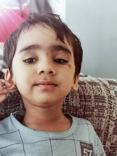 Adorable Young Boy Relaxing on a Couch with a Subtle Smile