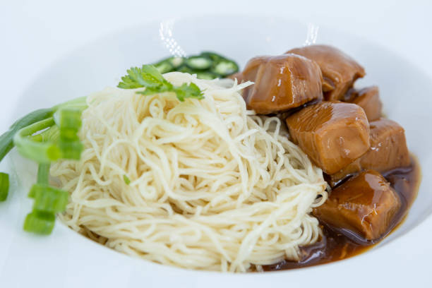 Chinese noodle with chicken gravy sauce, Close up of delicious chicken gravynoodleson white background, Noodles with Hainanese-Style Chicken Gravy,Glazed chicken with gravy sauce