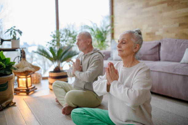 istock Elderly couple is doing yoga together. Home meditations. 2193373937