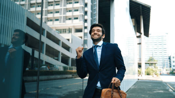 istock Skilled business man dancing with joyful while walking in glass wall. Exultant. 2193374919