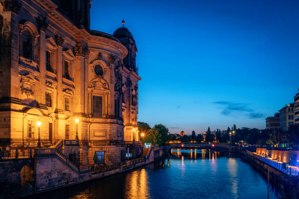 A serene nighttime scene of the Berlin Cathedral on the Spree River, showcasing glowing lights, architectural beauty, and a peaceful riverside atmosphere in the heart of Berlin, Germany.