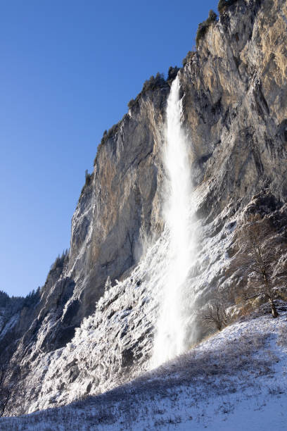 A waterfall in the Alps against a blue sky on a clear winter day