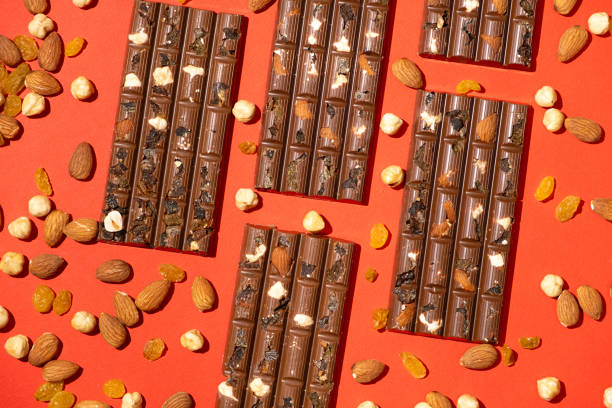 istock Lots of chocolate bars with nuts and raisins on a red background 2193380038