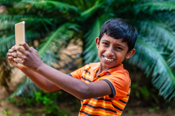Sri Lankan teenager using digital tablet near Sigiriya, Sri Lanka (Ceylon).