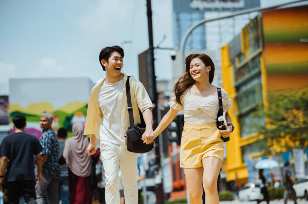 istock Young Asian couple holding hands while crossing the road. 2193383943