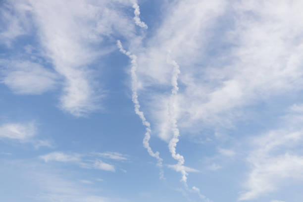 Traces in the sky from rockets. Beautiful blue sky with clouds.