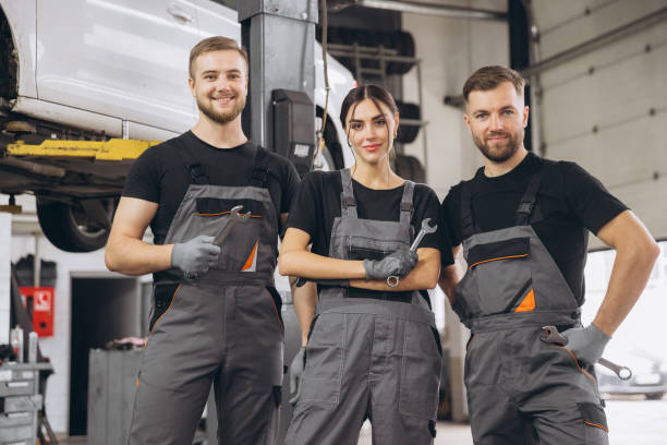 istock Group of three car service technician men and woman talking at workplace, people working together at vehicle repair garage service shop, check and repair customer car at automobile service center. 2193384752