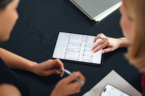 istock Two Coworkers Discussing a Floor Plan on a Tablet in Office Setting 2193393821