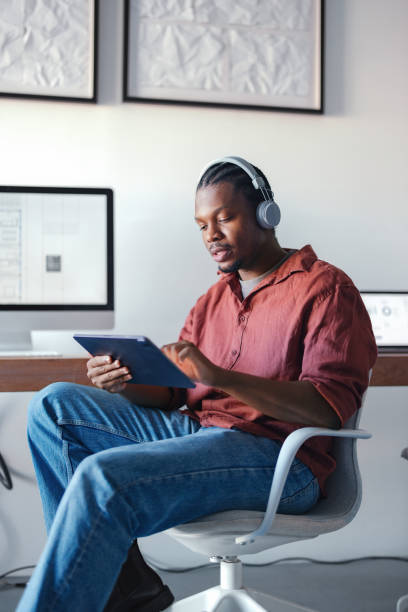 istock Young Designer Working on Tablet with Headphones in a Modern Studio 2193393851