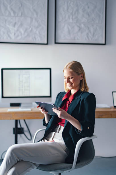 istock Smiling Businesswoman Using Tablet at Modern Office Workspace 2193393864