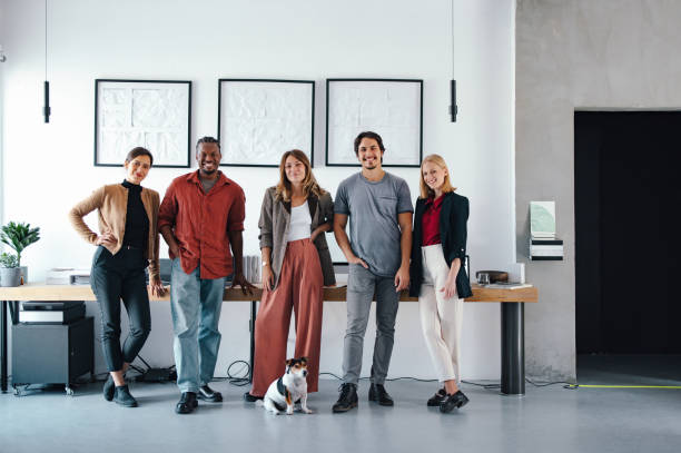 istock Young Professionals in Design Studio Posing Together with Small Dog 2193393901