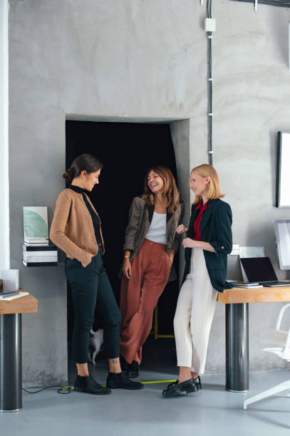 istock Coworkers Standing Together in a Modern Office Setting Engaged in Conversation 2193393908