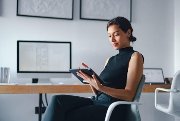 Professional Woman Using Tablet in Modern Business Office Setting