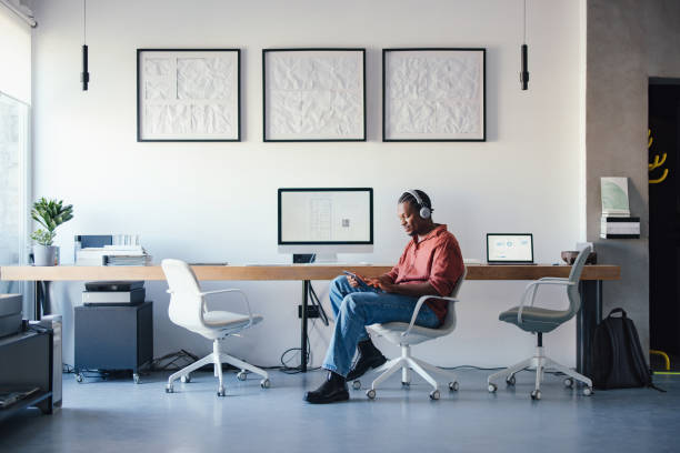 istock Modern Office Scene With Person Working on Tablet and Headphones On 2193393926