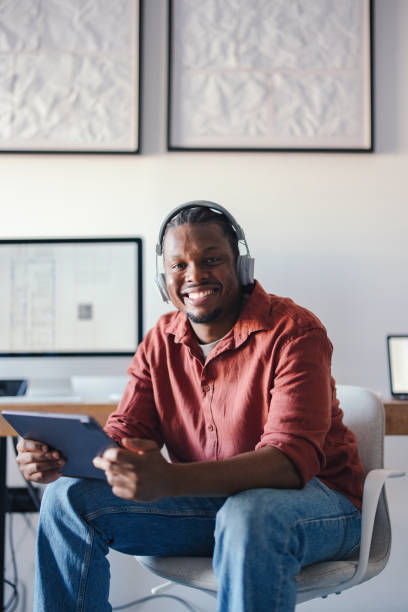 istock Smiling Professional Listening to Audio While Working in a Modern Office Environment 2193393962