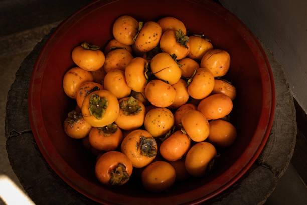 Fresh persimmon in the bowl harvest top view