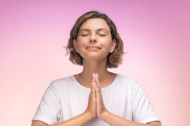istock Serene Woman in Namaste Pose with Closed Eyes Against Gradient Background 2193396704