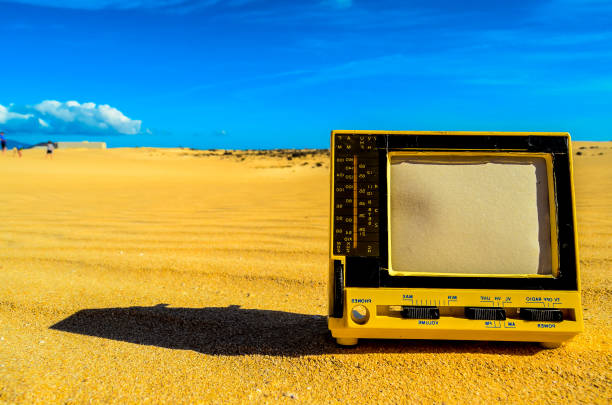 istock A yellow television is sitting on the sand in a desert 2193398143