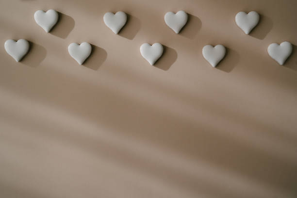 istock A grid of evenly spaced white ceramic hearts on a beige background with copy space. Simple clean design suitable for creative projects, backgrounds, or romantic occasions. Perfect for Valentine's Day 2193399757
