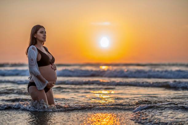 istock pregnant woman on the beach 2193400235