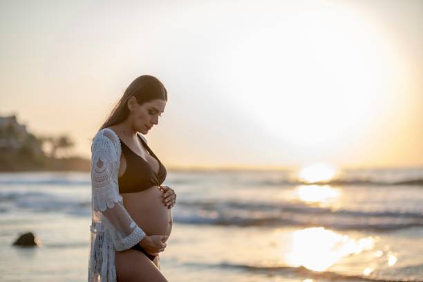 istock pregnant woman on the beach 2193400239