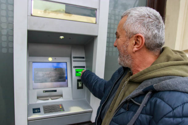 istock Happy senior man using money from ATM 2193408665