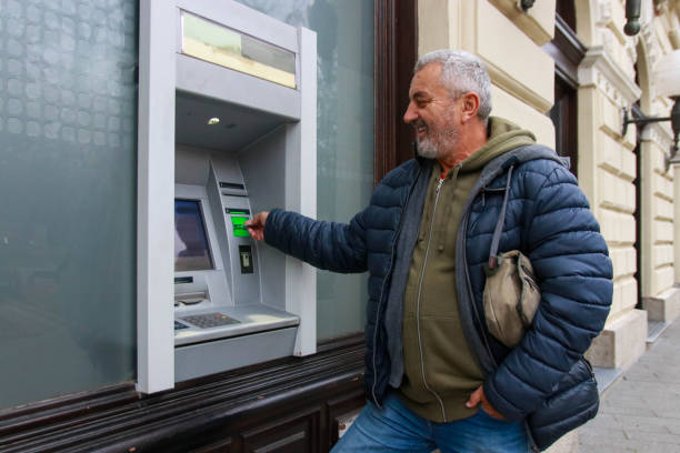 istock Happy senior man using money from ATM 2193408667