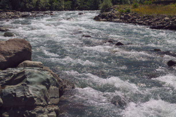 Blurred flowing waters of a stream around the stones.
