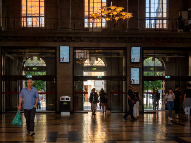 Arriving and departing in the main entrance hall at Aarhus railway station. Aarhus is a port city in eastern Jutland, mainland Denmark.