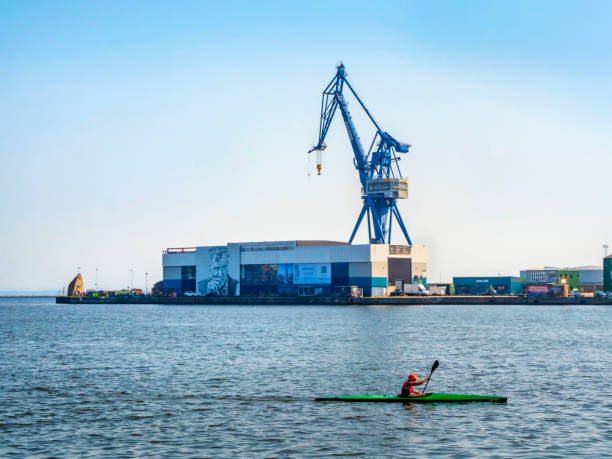 A canoeist paddling across part of the harbour in Aarhus, Jutland, mainland Denmark on a sunny summer day.