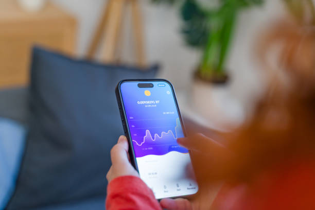 istock Woman checking bitcoin price chart on smartphone at home 2193413519