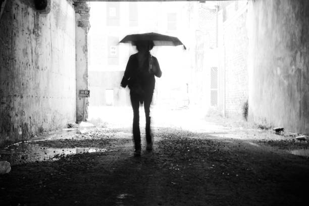 istock Silhouette of Person Holding Umbrella Backlit 2193417536