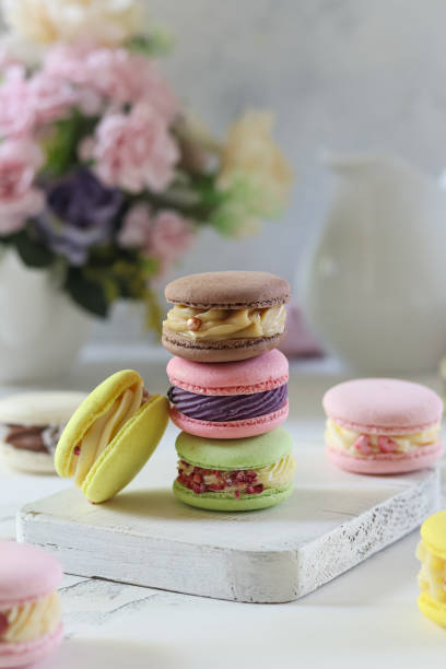 istock Assorted colorful macarons stacked elegantly on a wooden board with a floral backdrop 2193418774