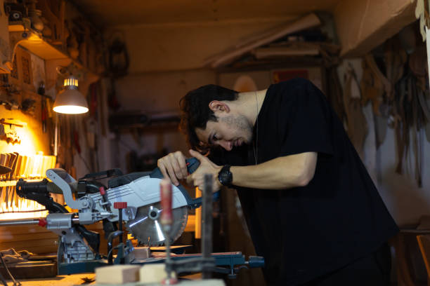 istock Carpenter cutting wood with circular saw in workshop 2193420582