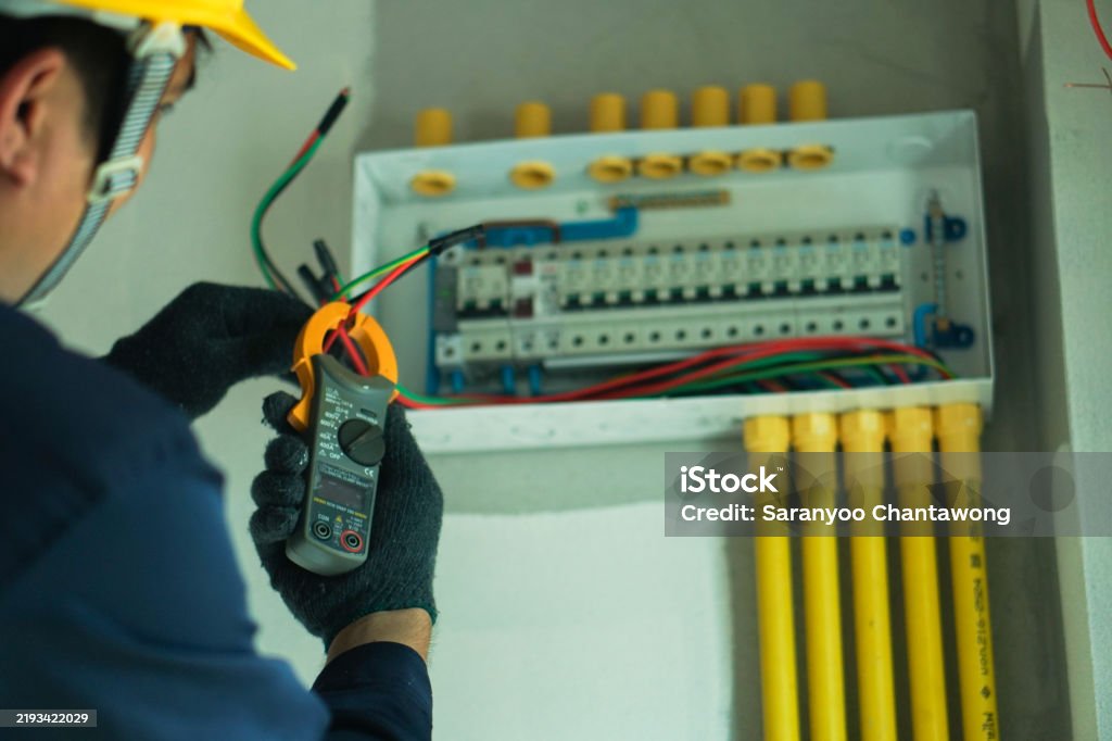 Using Electric Devices An Electrician Is Using A Device To Check The Electrical Current For ...