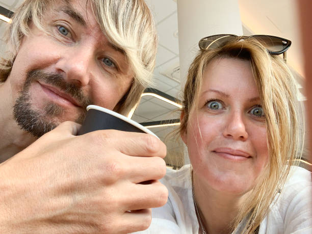 istock a man and woman smiling, holding a coffee cup, 2193429821