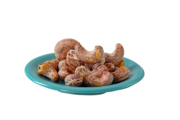 Roasted salted cashew nuts on white background.