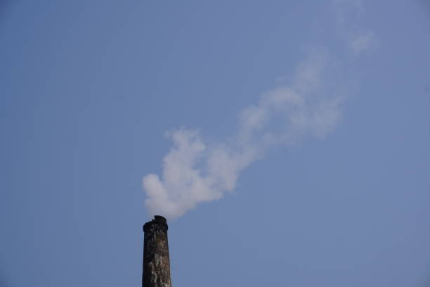 The white smoke is coming out from the chimney with blue sky background