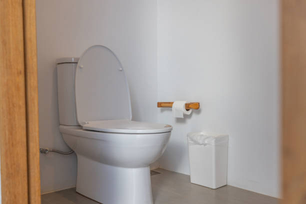 Sleek bathroom featuring a white toilet and clean lines. Minimalist restroom with a simple style. Functional and contemporary bathroom interior design.