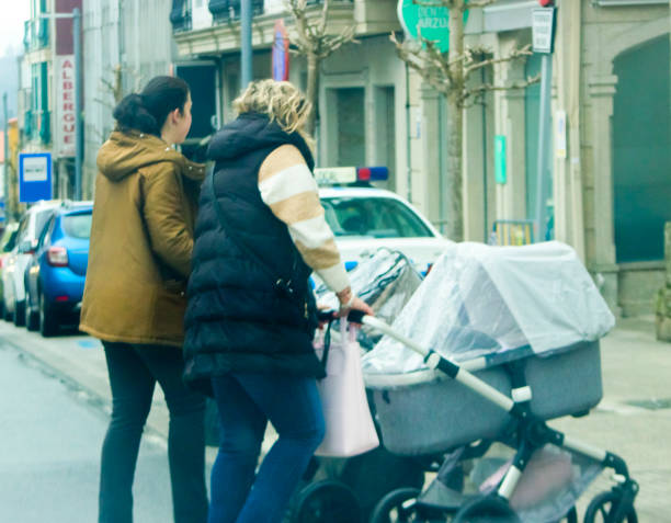 Women pushing baby strollers in a rainy day. Galicia, Spain.