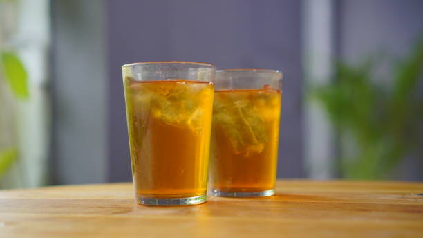 Refreshing black iced tea served in a clear glass on a wooden table