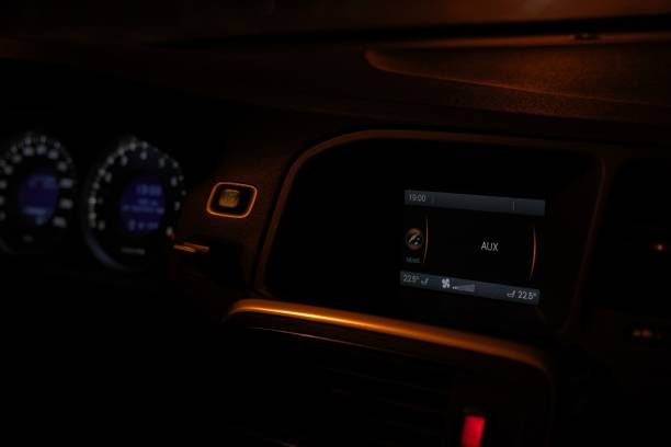 Car interior, control panel of audio player and other devices close-up, automobile dashboard at night, car driving in the dark time of day