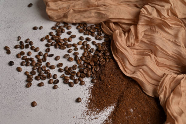 Fresh aromatic grain and ground coffee, white background, brown cloth