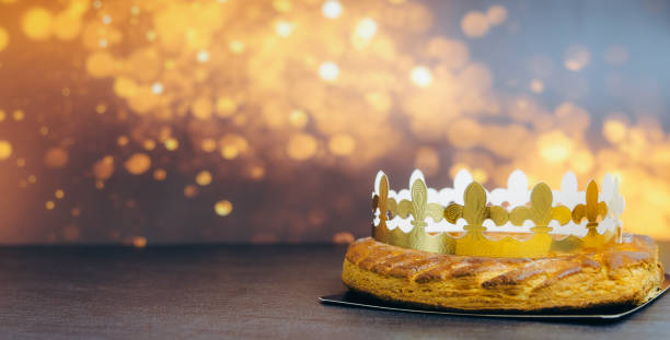 Whole almond royal pie with crown on stone table with fire bokeh.