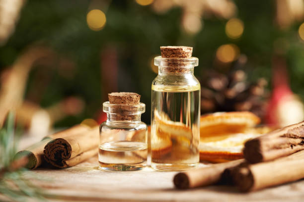 istock Two bottles of aromatherapy essential oil with Ceylon cinnamon sticks and Christmas decoration on a table 2193454872
