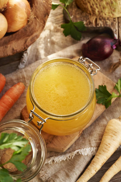 istock Bone broth in a glass jar on a table with fresh vegetables 2193455792
