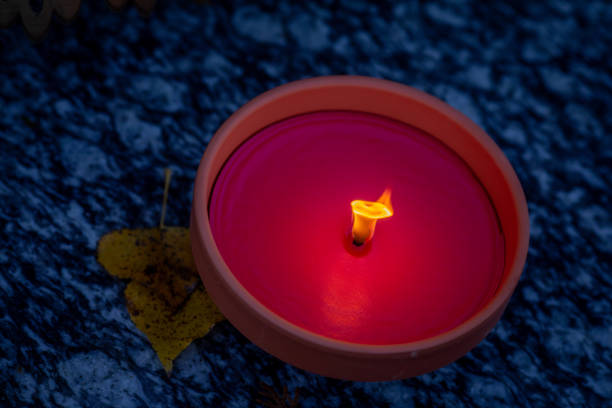 A beautifully glowing pink candle gently rests on a textured surface, creating a soothing and calming ambiance