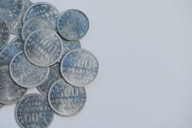 Silver German old reichsmark coins are arranged haphazardly, displaying intricate engravings.