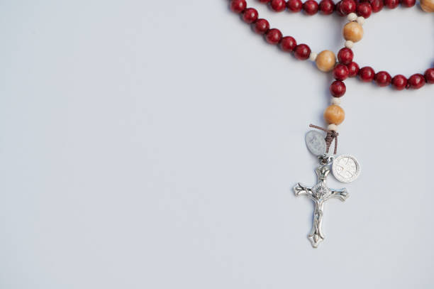 Rosary displayed for prayer with wooden beads against a simple white background